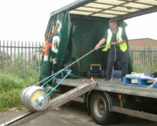 Fig. 1a: Employee using clamping device to roll the keg off the truck.