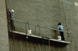 Figure 15. This scaffold does not have guardrails along all open sides and ends and has no midrail, and its occupants are not wearing personal fall-arrest systems.