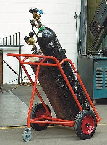 Cylinder being moved with a three-wheeled trolley keeping it angled