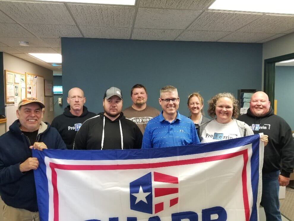 Employees standing with the SHARP flag