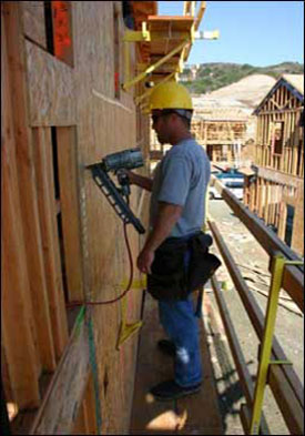 Figure 29 - A worker sheathing walls from an exterior bracket scaffold. For problems with accessibility in using figures and illustrations, please contact the DOC at 202-693-2020.