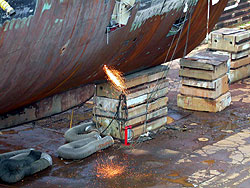 Figure 1: Ship's hull being cut with torch from inside of vessel.