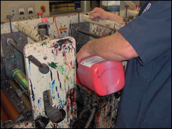 Figure 27. Awkward bending of the wrist when pouring ink into ink fountains on press.