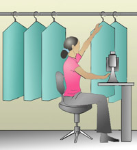 Fig. 1 Reaching overhead to pick up fabric can cause stress on the arms, neck, and shoulders.