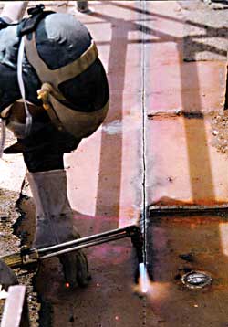Figure 1: Worker cutting weather deck with torch.