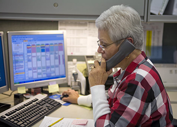 Worker on phone at computer desk