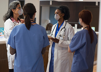 Discussion between healthcare workers wearing masks