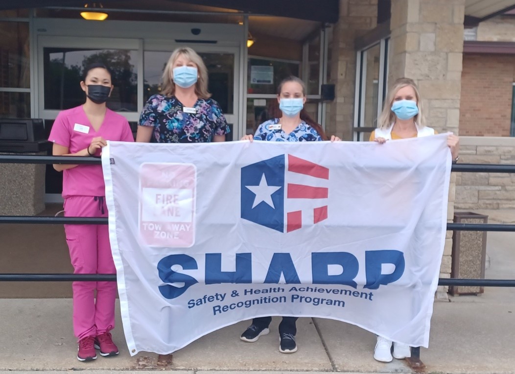 Employees proudly holding the SHARP flag.